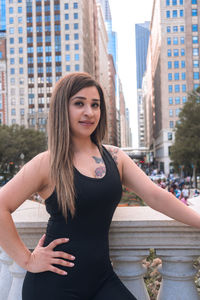 Portrait of smiling woman standing in city