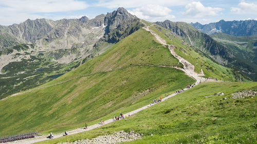 Crowds of tourists walking on the trail towards a prominent mountain in the background, poland, eu