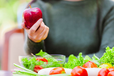 Midsection of woman holding strawberries