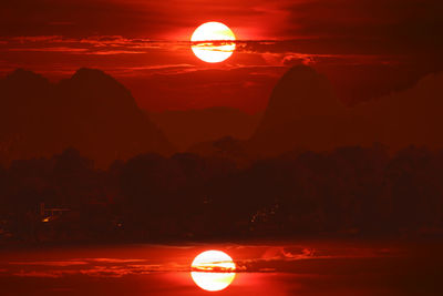 Scenic view of silhouette mountain against orange sky