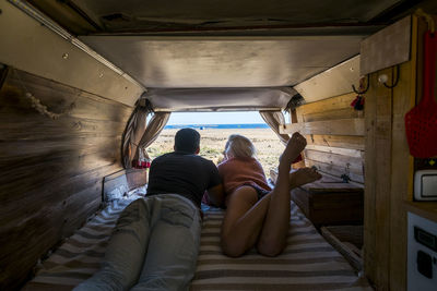 Rear view of couple lying down in motor home