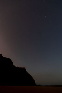 Scenic view of silhouette field against sky at night
