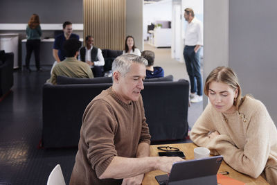 Two professionals working together in office cafeteria