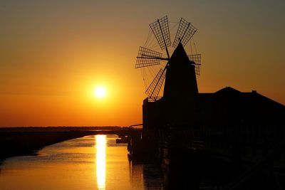Scenic view whit mill of sea against sky during sunset. marsala saline, trapani sicily, italy 