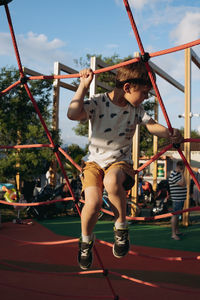 Low angle view of boy playing in playground