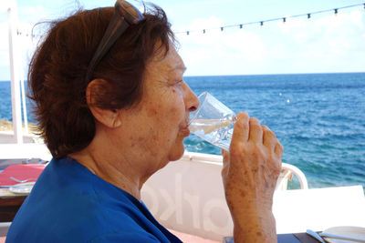 Woman drinking water at sea