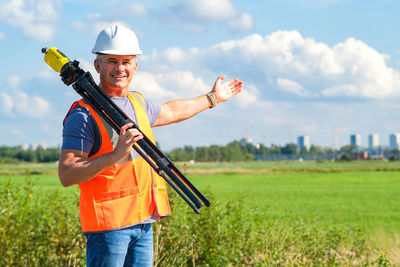 Portrait of man holding umbrella on field