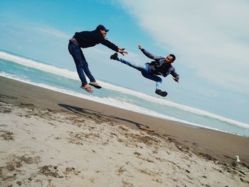 Low angle view of people on beach against sky