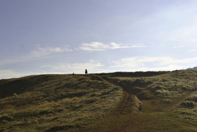 Lighthouse on field against sky