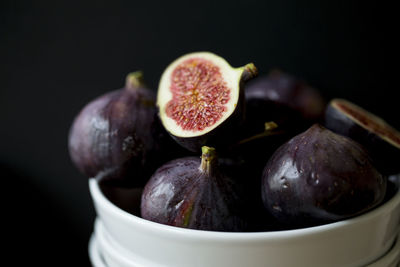 Close-up of fruits in bowl against black background