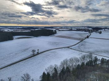 Scenic view of snow covered land against sky