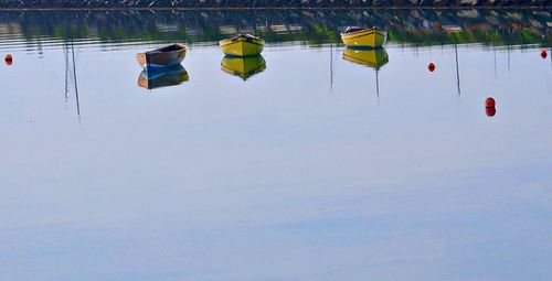 Reflection of people in lake against sky