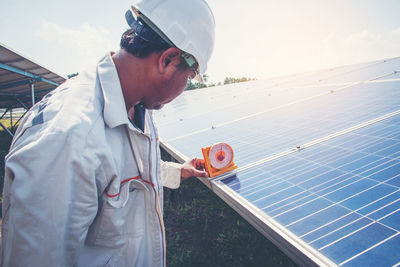 Engineer holding measuring equipment on solar panel