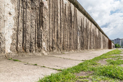 Damaged historic berlin wall against sky