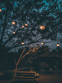 Low angle view of illuminated trees against sky at night