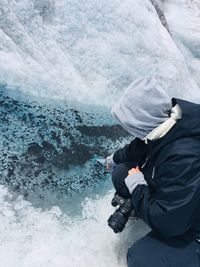 High angle view of person filling water bottle from river