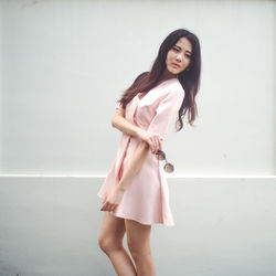 Portrait of smiling young woman against white background