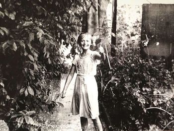 Portrait of smiling girl standing against plants