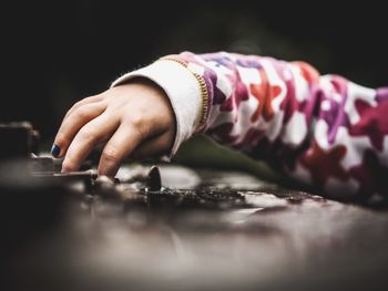 Cropped hand of girl touching table