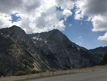 Scenic view of road by mountains against sky