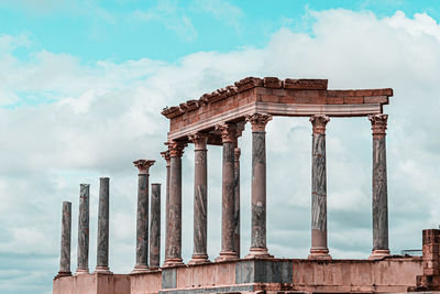 Low angle view of old building against cloudy sky