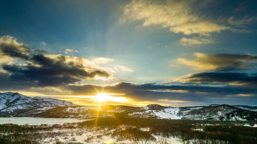 Scenic view of snowcapped mountains against sky during sunset