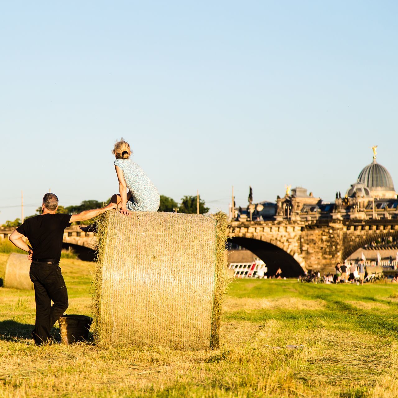 leisure activity, clear sky, grass, lifestyles, copy space, architecture, built structure, building exterior, childhood, casual clothing, standing, park - man made space, playing, field, plant, day, grassy, outdoors, green color, person, young adult