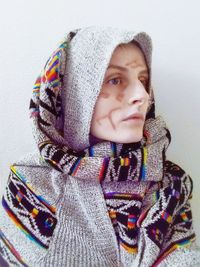 Portrait of woman wearing warm clothing standing against white background