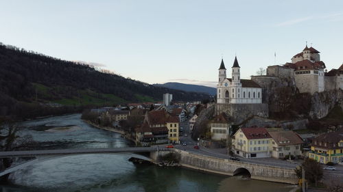 River amidst buildings in city against clear sky