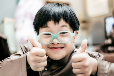 An autism boy smiling with thumbs up gesture