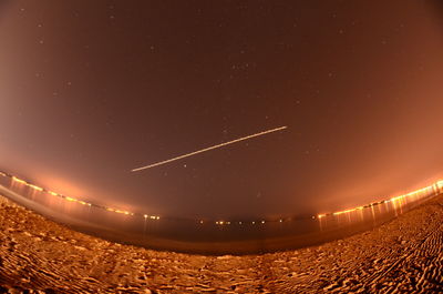 Low angle view of illuminated lights against sky at night