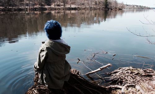 Rear view of person sitting at vinterviken lakeshore