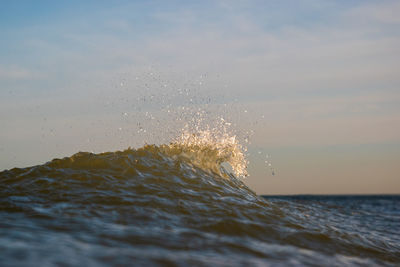 Water splashing in sea against sky