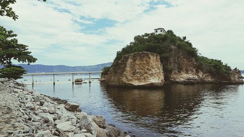 Rock formations by sea against sky