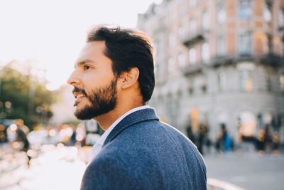 Portrait of young man looking at city