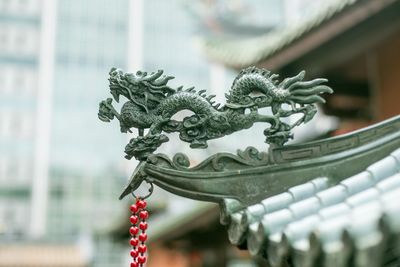 Close-up of chinese dragon statue on temple roof