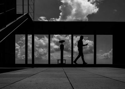 Side view of silhouette man by window sill