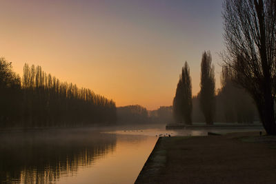 Scenic view of lake against clear sky during sunset