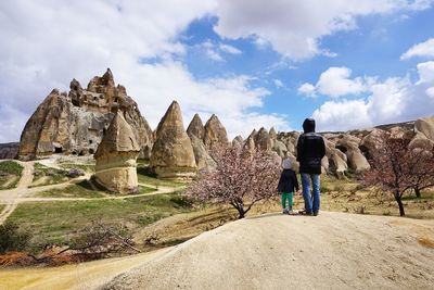 Rear view of mother standing with daughter on field at cappadocia