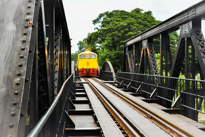 Yellow train on railway bridge