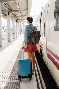 Rear view of woman standing on train