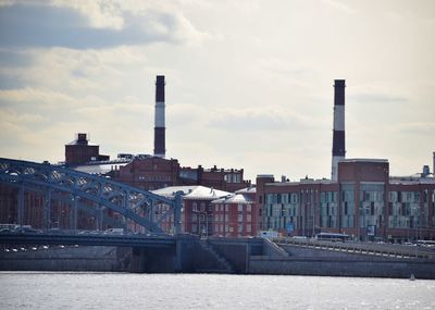 Smoke emitting from factory against sky