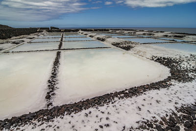 Scenic view of salt pan against sky