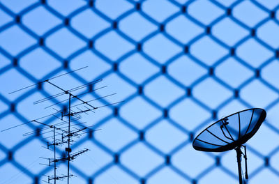 Low angle view of basketball hoop seen through chainlink fence