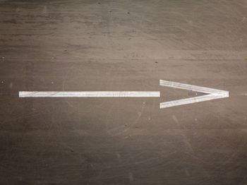 High angle view of arrow sign on floor
