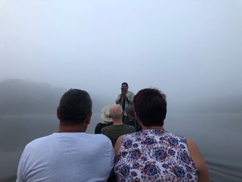 Rear view of man and woman looking at view against sky