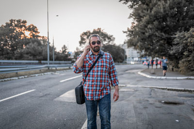 Portrait of handsome businessman with sunglasses and plaid shirt . he talks over his mobile phone