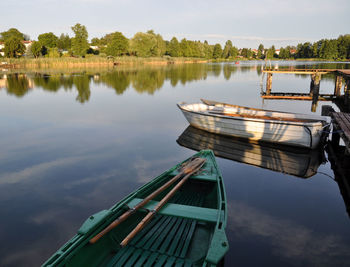 Boat moored on lake against sky
