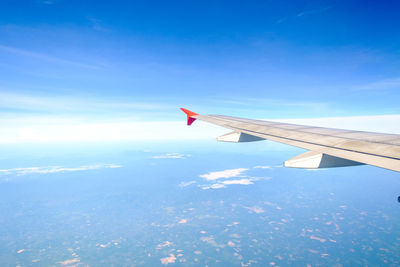 Aerial view of airplane wing against blue sky