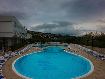 Fountain in swimming pool against sky